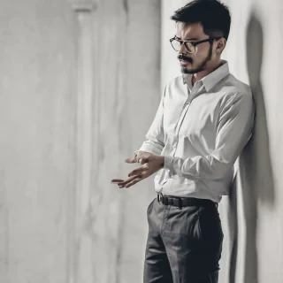 a man standing waist up wearing a office shirt looking amazed